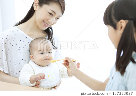 Girl feeding a baby Girl feeding a baby 137353087
