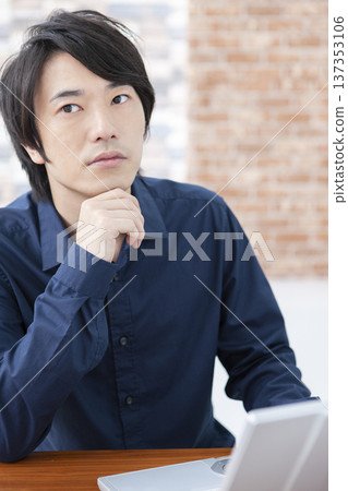 一個操作筆記本電腦的人 137353106