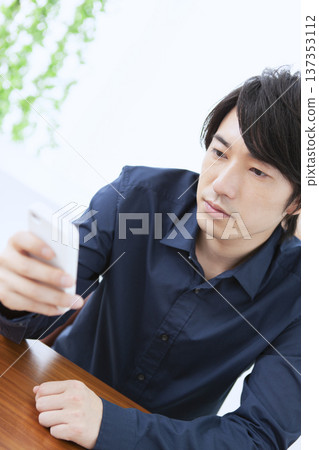 A man operating a smartphone 137353112