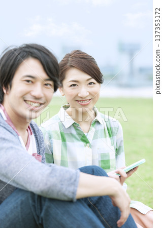 一對夫妻坐在草坪上 137353172