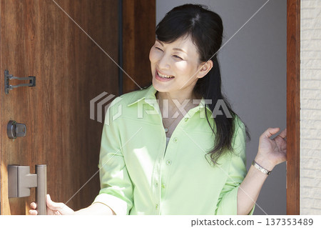 Woman opening the front door 137353489