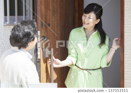 Couple talking at the front door 137353551