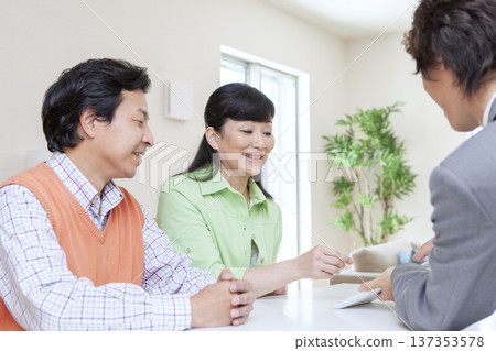 A couple having a meeting with a salesman A couple having a meeting with a salesman 137353578