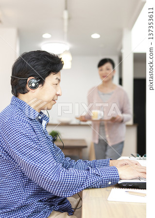 一名男子正在操作電腦，一名女子拿著茶。 137353611