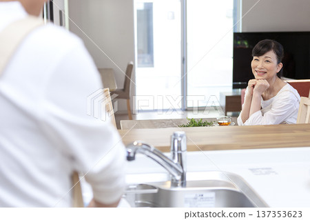 一名男子在洗碗，一名女子在放鬆。 137353623
