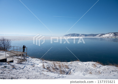 Tourist looking to beautiful view of Angara river and lake Baikal at Listvyanka a town with less than 2,000 inhabitants in Irkutsk Oblast on the shore of Lake Baikal, Russia. Tourist looking to beautiful view of Angara river and lake Baikal at Listvyanka a town with less than 2,000 inhabitants in Irkutsk Oblast on the shore of Lake Baikal, Russia. 137355821