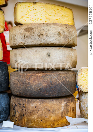 Stacked aged cheese wheels displaying rustic texture and ready for market sale Stacked aged cheese wheels displaying rustic texture and ready for market sale 137356164