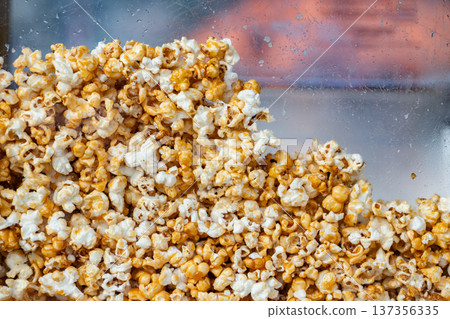 Caramel popcorn pile close-up in a clear display case 137356335