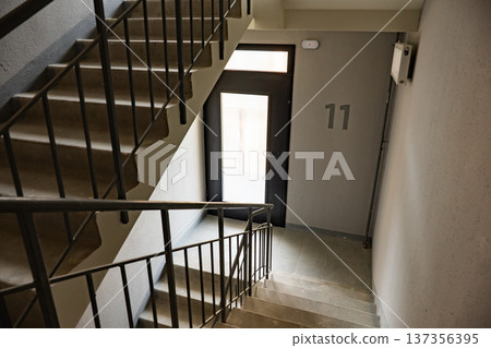 Concrete staircase in a residential building with a doorway to apartment 11 Concrete staircase in a residential building with a doorway to apartment 11 137356395