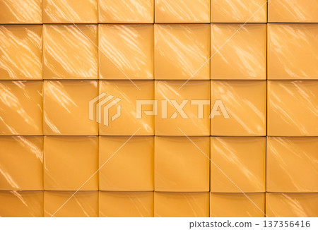 Yellow glossy ceramic tile wall with square pattern and light reflections 137356416