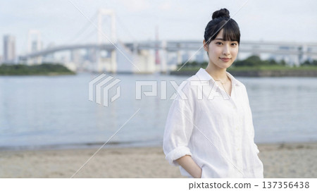 A refreshing Japanese woman wearing a white linen shirt at the beach in the morning 137356438