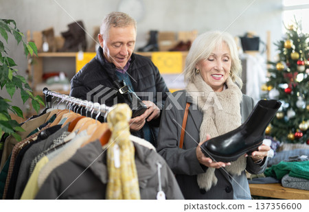 Elderly couple choosing platform boots on Christmas tree background 137356600