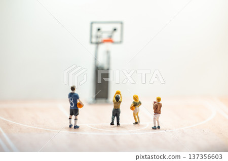 Miniature basketball players scoring a point on toy court, competition concept Miniature basketball players scoring a point on toy court, competition concept 137356603