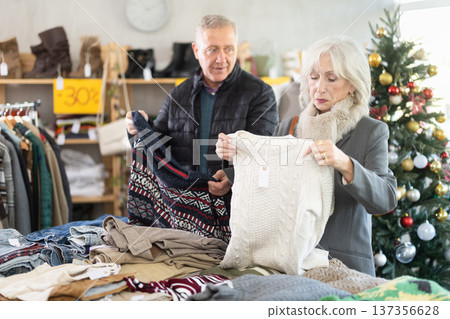 Selective mature man and woman choosing sweater in clothing store Selective mature man and woman choosing sweater in clothing store 137356628