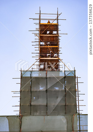 Scaffolding structure covering a building tower during a modernization project Scaffolding structure covering a building tower during a modernization project 137356629