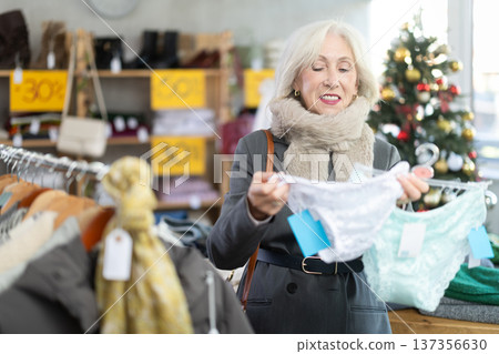 Mature woman choosing panties in the store against the background of the Christmas tree 137356630