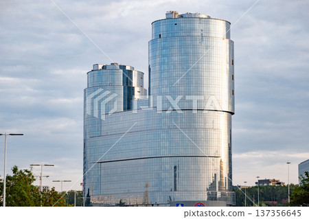 Glass facade skyscraper in Vilnius business district reflecting changing sky Glass facade skyscraper in Vilnius business district reflecting changing sky 137356645