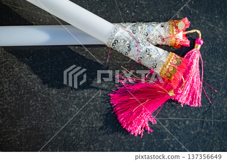 Ceremonial candles decorated with pink tassels and shiny sequins for a festive tradition Ceremonial candles decorated with pink tassels and shiny sequins for a festive tradition 137356649