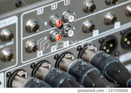 Professional sound mixer panel with various audio connections and XLR cables plugged in Professional sound mixer panel with various audio connections and XLR cables plugged in 137356660