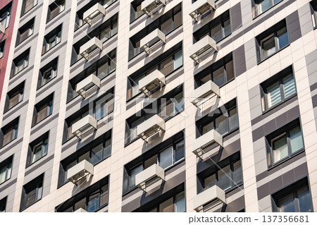 Residential building facade showing modern architecture and many windows with air conditioners Residential building facade showing modern architecture and many windows with air conditioners 137356681