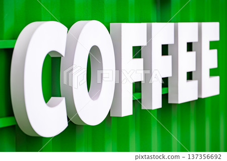 Coffee lettering sign on a vibrant green corrugated metal wall outdoors 137356692