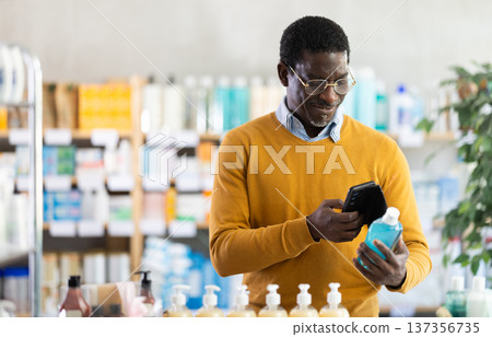 Man scanning mouthwash for ingredients and info in drugstore Man scanning mouthwash for ingredients and info in drugstore 137356735