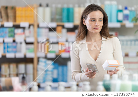 Girl in summer clothes looking for medicine in pharmacy 137356774