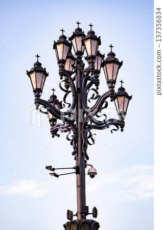 Ornate lamppost with surveillance camera creating a contrast of old and new technology Ornate lamppost with surveillance camera creating a contrast of old and new technology 137356834