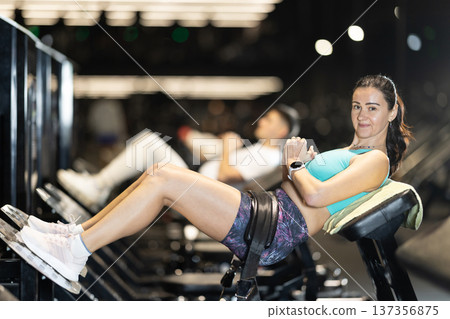Woman performing hip thrusts on glute bridge machine at gym Woman performing hip thrusts on glute bridge machine at gym 137356875