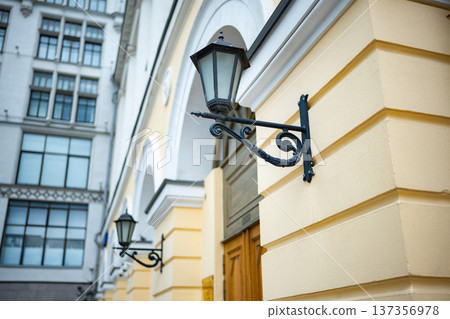 Ornate vintage street lamp on old building facade with classic architecture Ornate vintage street lamp on old building facade with classic architecture 137356978