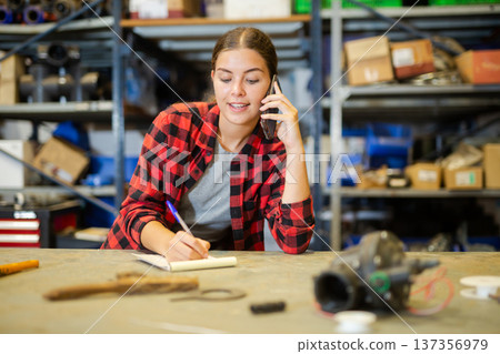Woman store warehouse employee talking on mobile phone with customer closeup 137356979