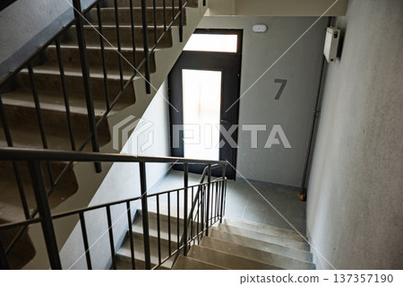 Concrete staircase leading to number seven door in an apartment hallway Concrete staircase leading to number seven door in an apartment hallway 137357190