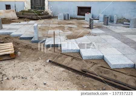 New stone tiles laying on sand during city street renovation and construction works New stone tiles laying on sand during city street renovation and construction works 137357223