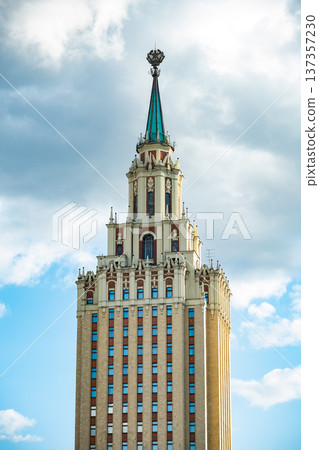 Moscow university building spire against cloudy blue sky, Stalinist architecture landmark Moscow university building spire against cloudy blue sky, Stalinist architecture landmark 137357230