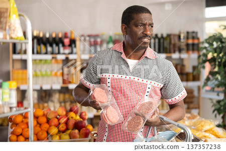 Adult man choosing hamburger in grocery store Adult man choosing hamburger in grocery store 137357238
