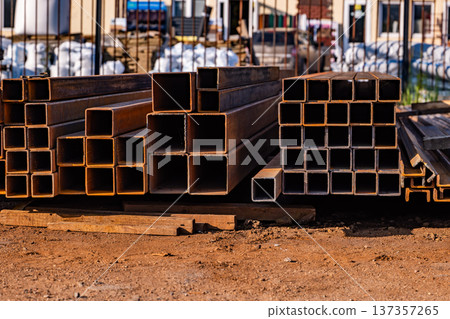 Stacked square steel profiles showing industrial building material at a construction site 137357265