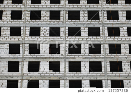 Modern building facade under construction with many windows and concrete structure Modern building facade under construction with many windows and concrete structure 137357286