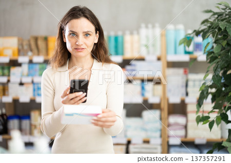 Woman in pharmacy scans QR code on pills box Woman in pharmacy scans QR code on pills box 137357291