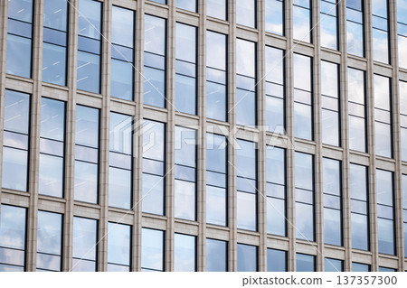 Modern building facade with reflective glass windows and geometric pattern 137357300