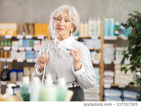pensioner chooses an ointment for joints 137357305