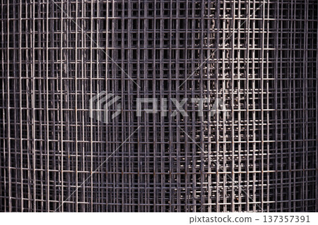 Metal wire mesh forming a repetitive industrial grid pattern for construction backgrounds 137357391