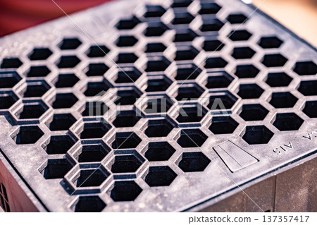 Repeating honeycomb pattern creating textured grid on black plastic surface 137357417