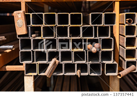 Stacked square steel pipes or metal profiles in a warehouse for industrial construction 137357441
