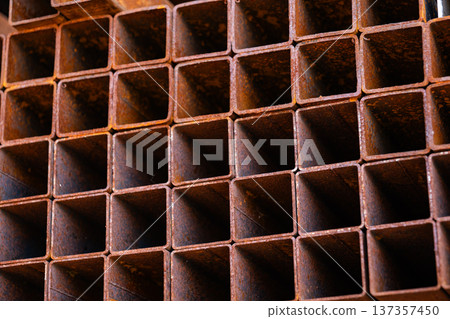 Rusty square metal pipes forming a grid pattern for industrial construction background Rusty square metal pipes forming a grid pattern for industrial construction background 137357450