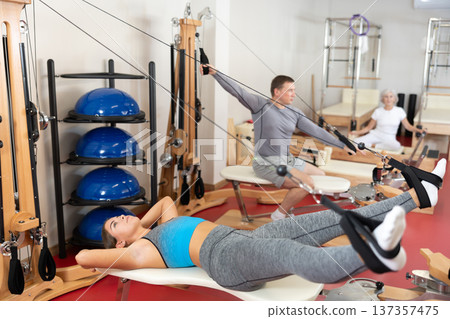 Young woman training her legs using straps Young woman training her legs using straps 137357475