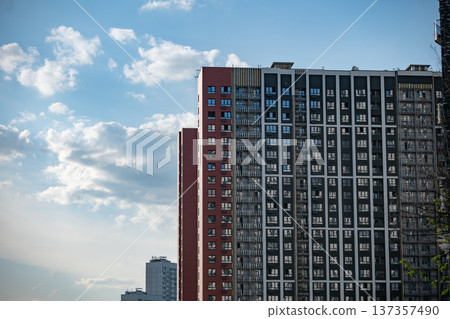 Modern residential urban buildings against a vibrant blue sky with white clouds 137357490