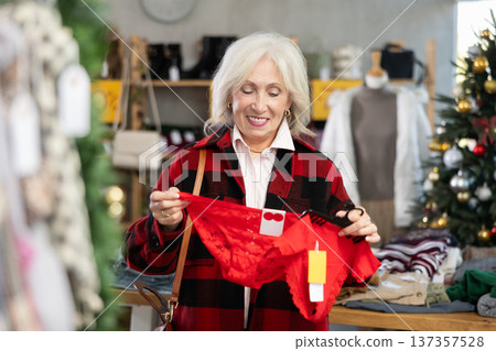 Elderly woman choosing red panties in the store Elderly woman choosing red panties in the store 137357528