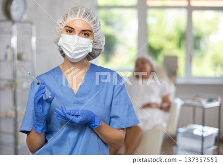 Young doctor with mask and syringe Young doctor with mask and syringe 137357551