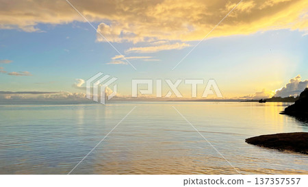 A calm sea and fantastical golden clouds at sunrise in Nakijin Village, Okinawa Prefecture A calm sea and fantastical golden clouds at sunrise in Nakijin Village, Okinawa Prefecture 137357557