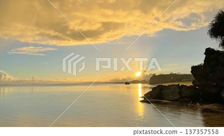 A calm sea and fantastical golden clouds at sunrise in Nakijin Village, Okinawa Prefecture A calm sea and fantastical golden clouds at sunrise in Nakijin Village, Okinawa Prefecture 137357558